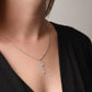 vertical silver name necklace on model
